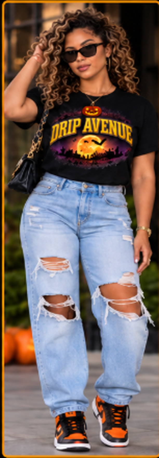 Woman wearing a black Drip Avenue Halloween graphic tee, light blue distressed jeans, sunglasses, and orange-accented sneakers