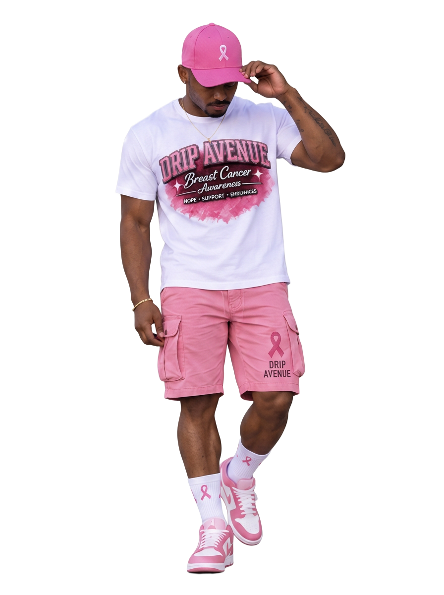 Full-body male model wearing a white Drip Avenue Breast Cancer Awareness shirt, pink cargo shorts and cap, and pink and white sneakers